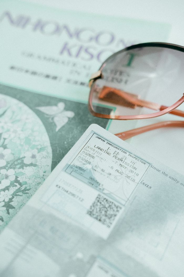 Close-up of passport, sunglasses, and travel ticket highlighting travel essentials.